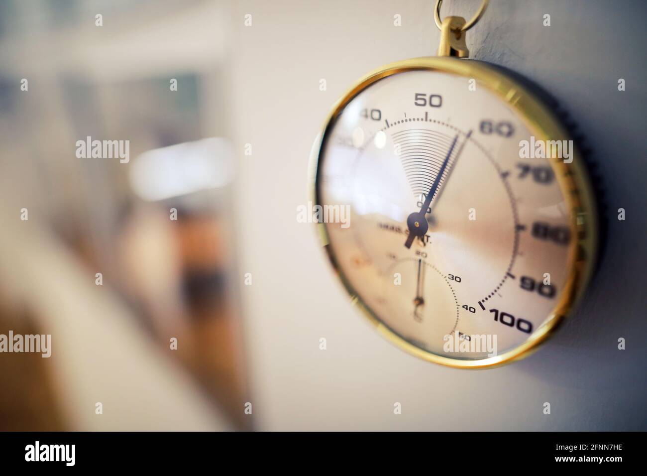 Details zur geringen Schärfentiefe (selektiver Fokus) mit einem analogen Hygrometer an der Wand eines Museums. Stockfoto
