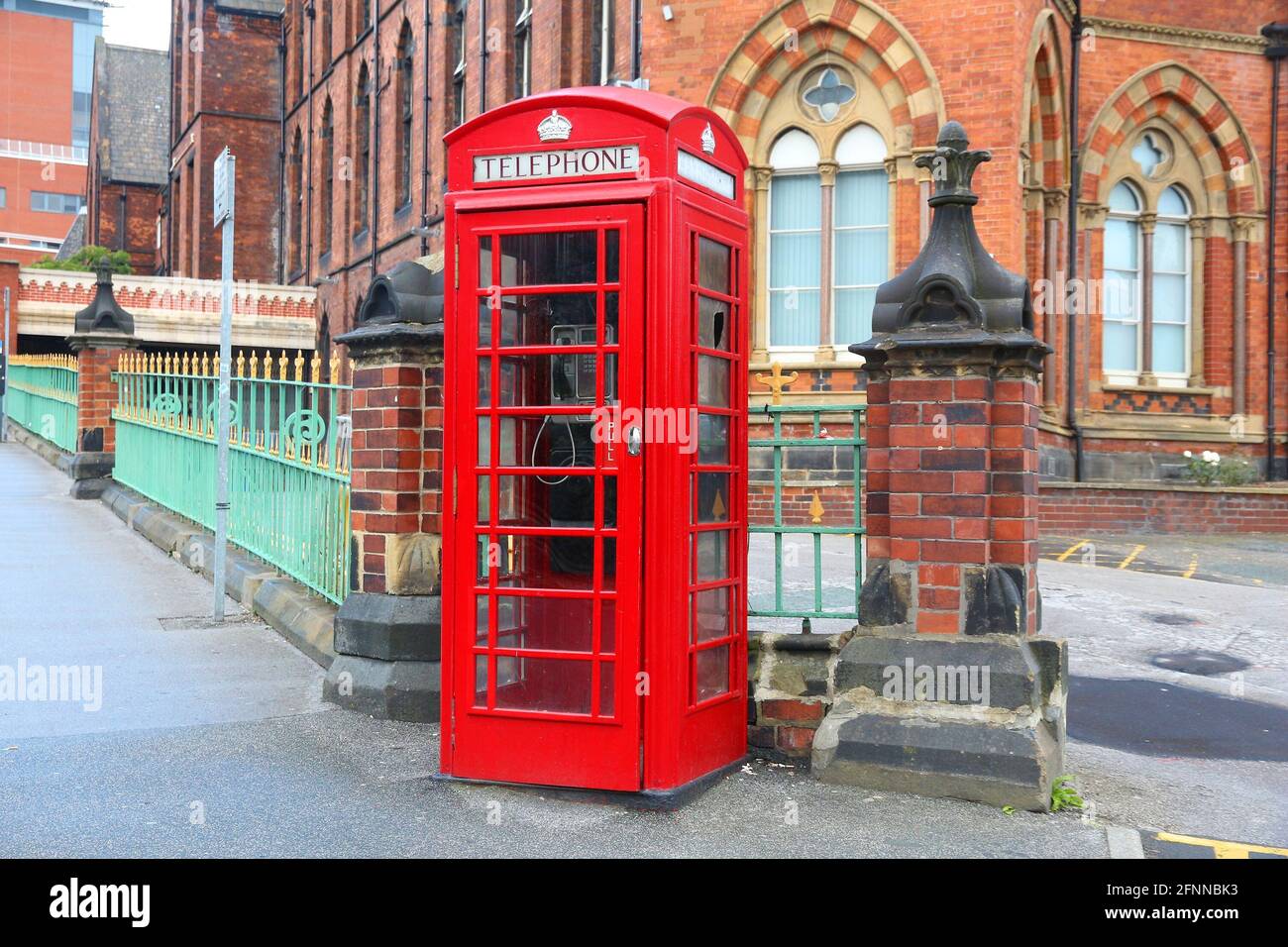 Leeds City, Großbritannien. Rotes Telefon und Leeds General Infirmary im Hintergrund. Stockfoto