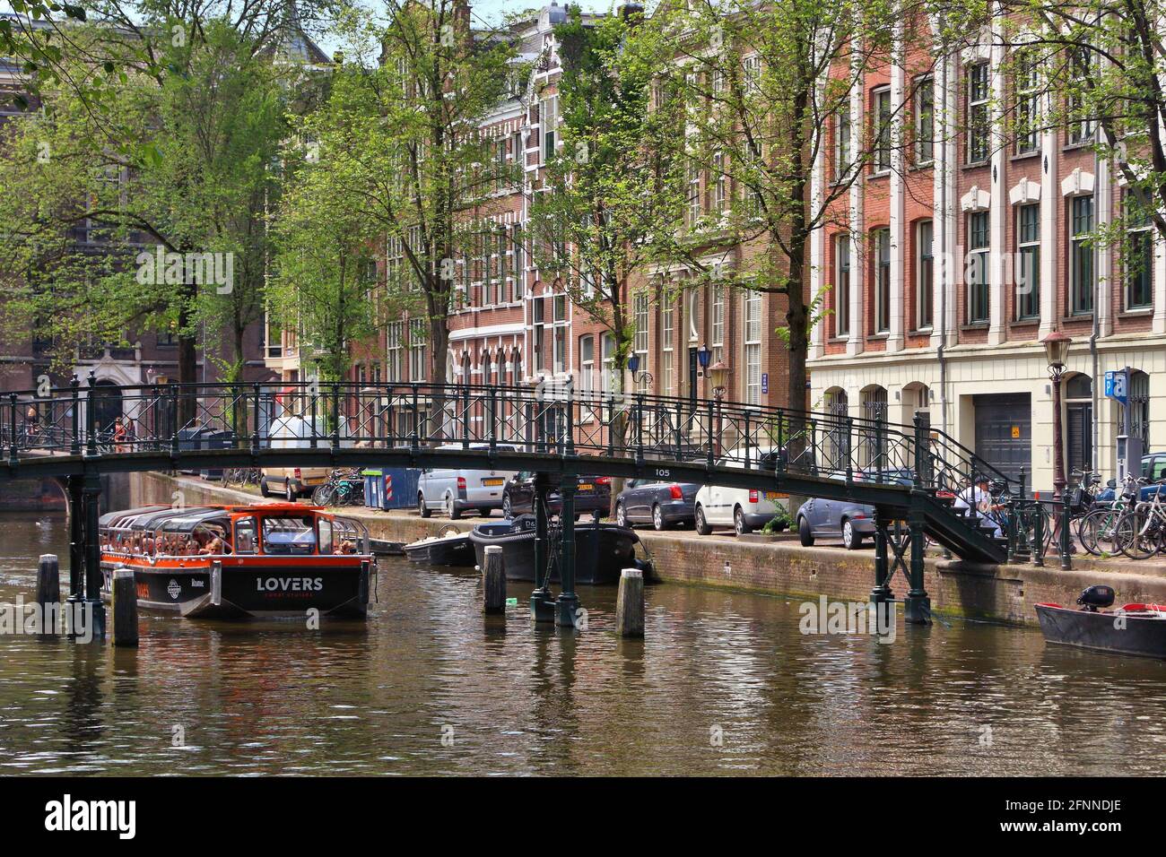 AMSTERDAM, NIEDERLANDE - 10. JULI 2017: Besucher besuchen den Oudezijs Voorburgwal Kanal in Amsterdam, Niederlande. Der Canal Ring aus dem 17. Jahrhundert liegt in der Nähe der Stadt Stockfoto