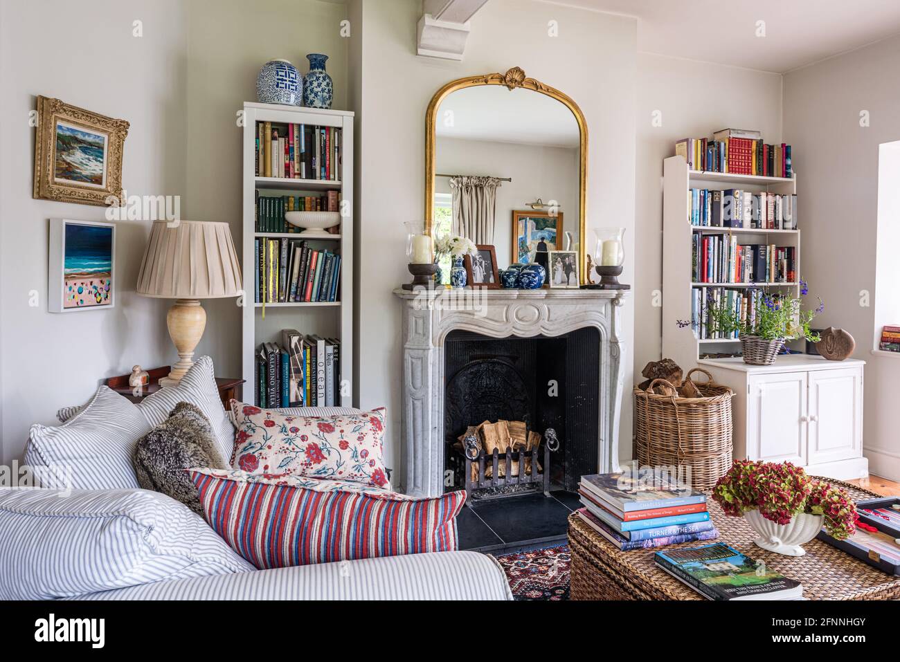Vergoldeter Spiegel am Kamin mit Bücherregal in viktorianischer Hütte aus dem 19. Jahrhundert. Stockfoto