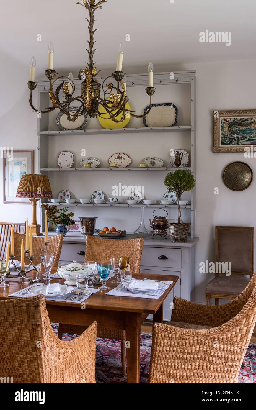 Korbsessel und Kommode mit Kerzenleuchtern in viktorianischer Hütte aus dem 19. Jahrhundert. Stockfoto