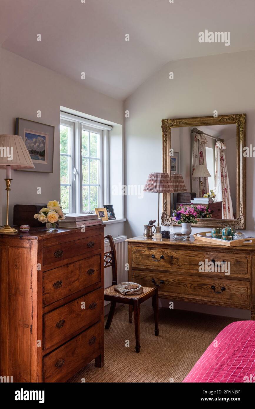 Goldgerahmter Spiegel über dem Frisiertisch mit einem Tallboy in einem viktorianischen Cottage aus dem 19. Jahrhundert. Stockfoto