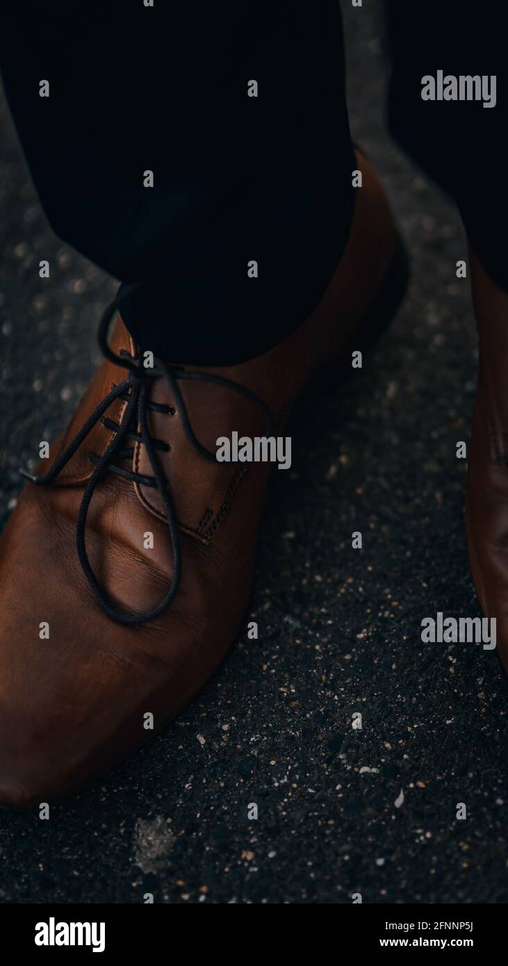 Vertikale Aufnahme eines Mannes mit braunen Lederschuhen Stockfoto