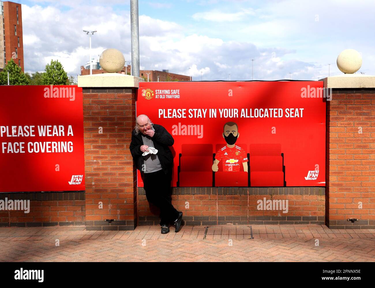 Ein Fan von Manchester United hat etwas zu essen, als er vor dem Stadion vor dem Premier League-Spiel in Old Trafford, Manchester, wartet. Bilddatum: Dienstag, 18. Mai 2021. Stockfoto