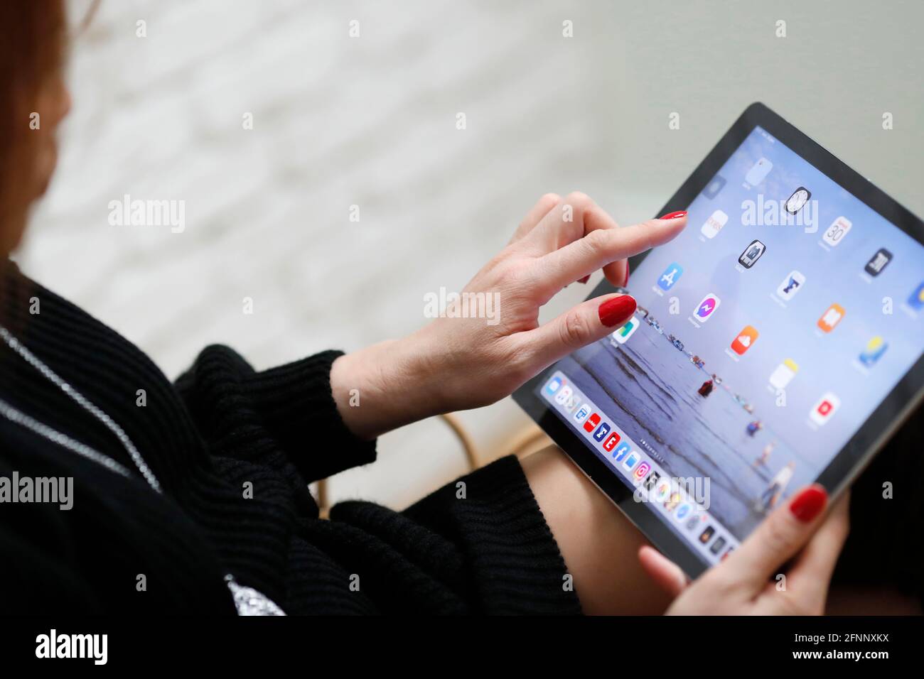 Frau, die Apps und Symbole auf einem digitalen Apple iPad-Tablet wählt. Frankreich. Stockfoto