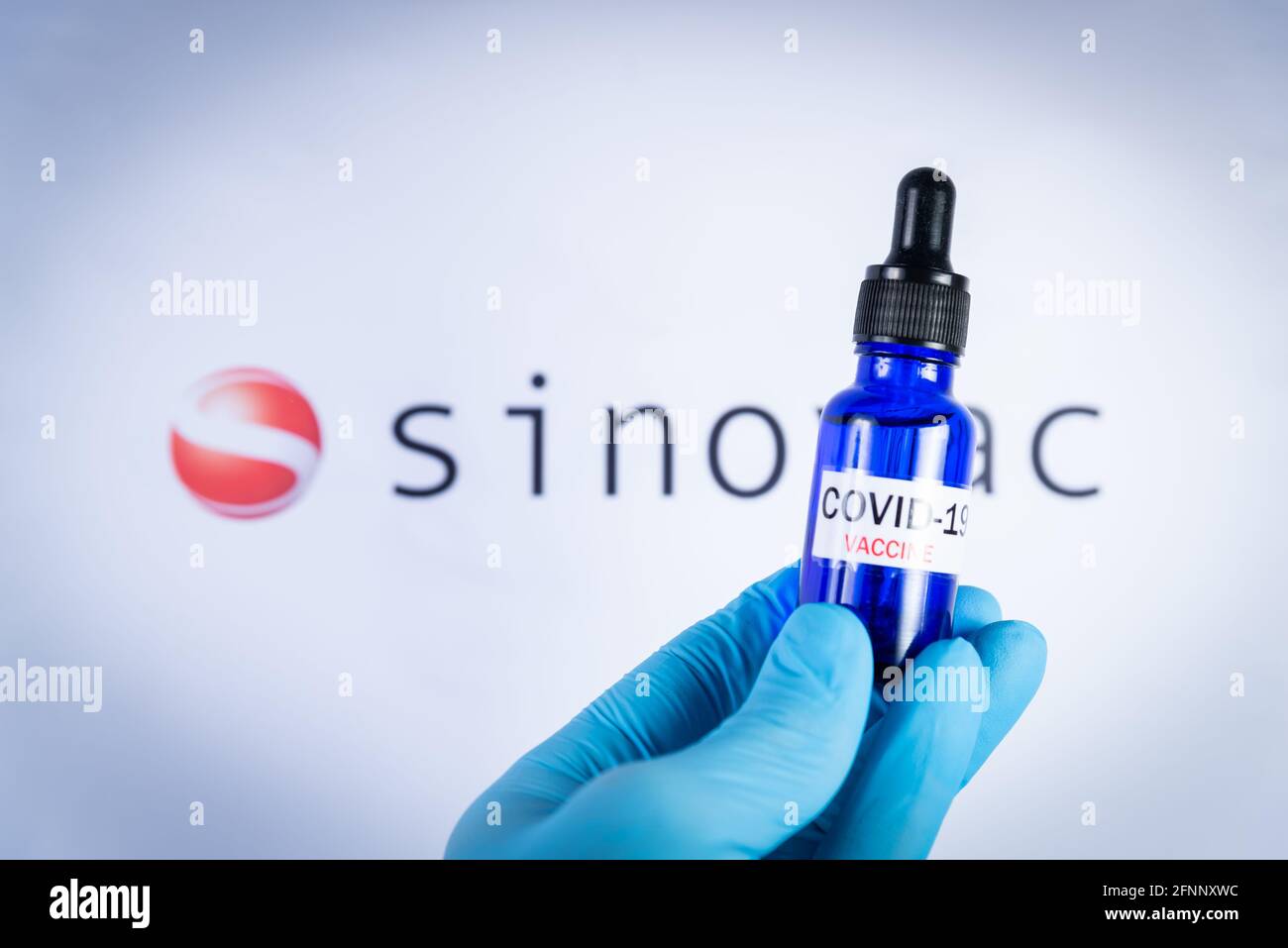 Am 18. Mai 2021 hält eine Hand eine Flasche vor dem Sinovac-Impfstofflogo in Barcelona, Spanien. Sinovac Biotech Ltd ist ein chinesisches Pharmaunternehmen pro Stockfoto