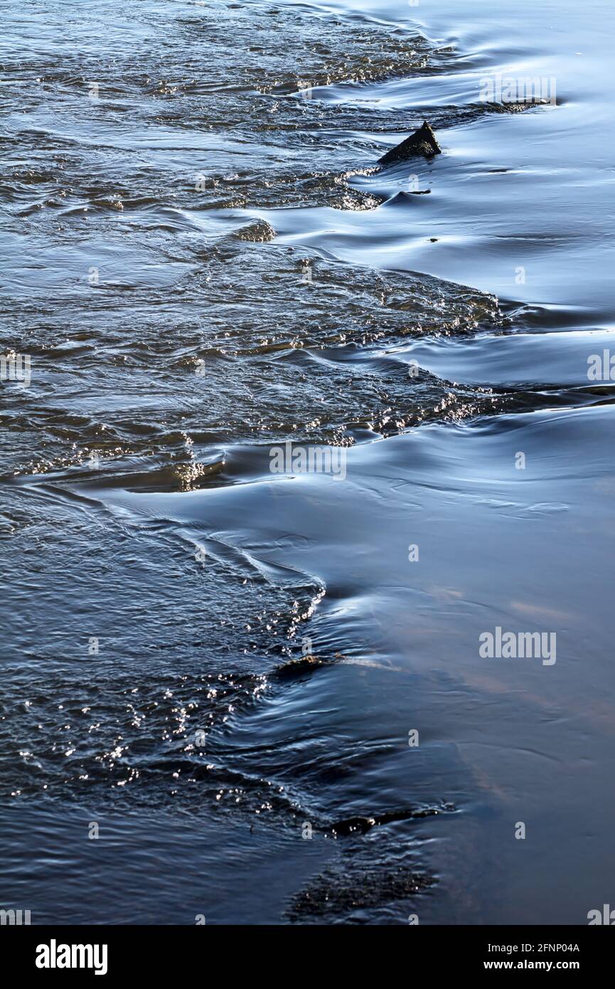 Ruhiges Wasser über Rocks Turning Turbulent, Großbritannien Stockfoto