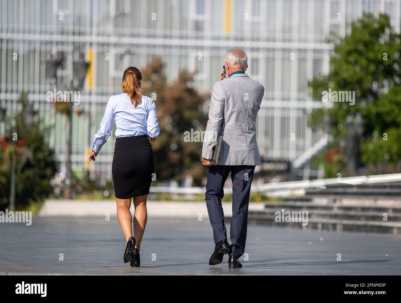Rückansicht des Geschäftsmannes und der Geschäftsfrau, die auf der Straße spazieren Stockfoto