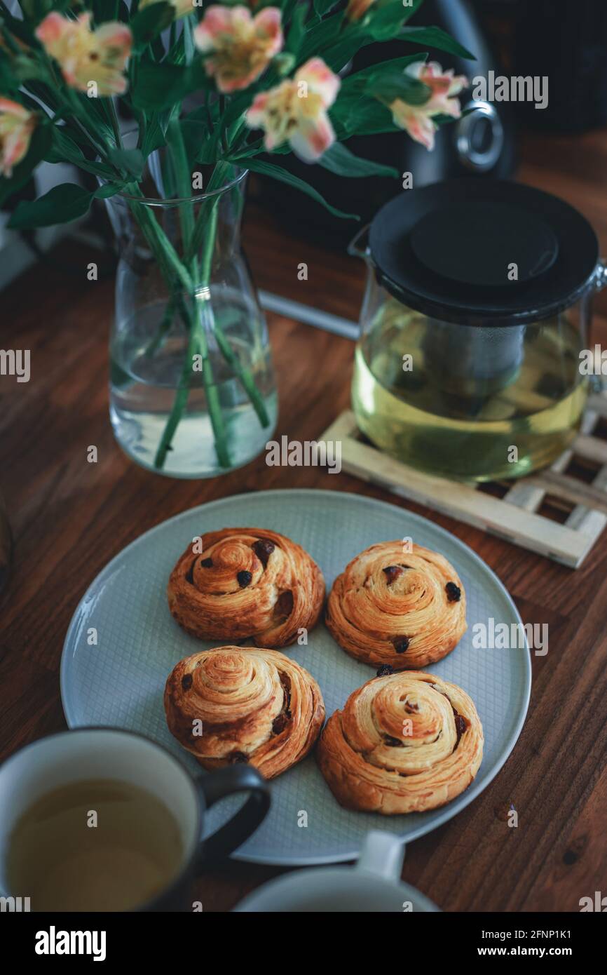 Hausgemachtes traditionelles Frühstück: Kaffee mit Brötchen, Schnecke mit Rosinen. Stockfoto