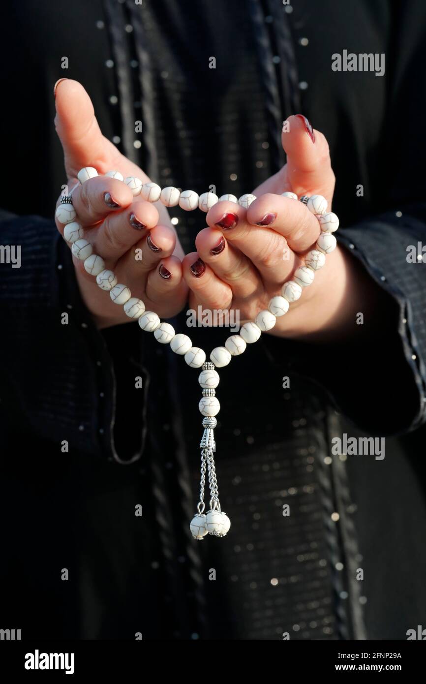 Nahaufnahme einer muslimischen Frau Hände in Abaya, während sie den Rosenkranz mit ihren Händen hält und betet. Religion beten Konzept. Vereinigte Arabische Emirate Stockfoto