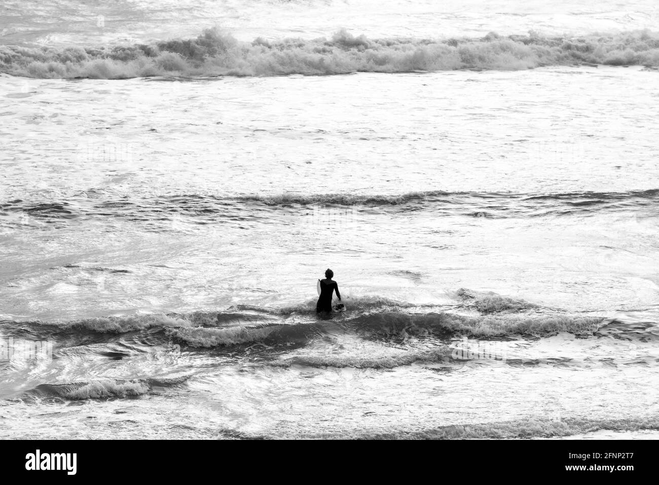 Ein Mann, der ins Meer geht, um zu surfen Stockfoto