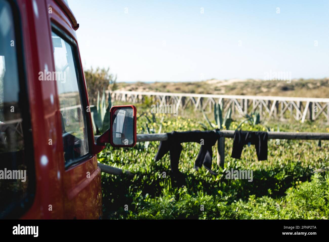 Ein Teil eines Transporters und einige Neoprenanzüge trocknen auf Ein sonniger Tag Stockfoto