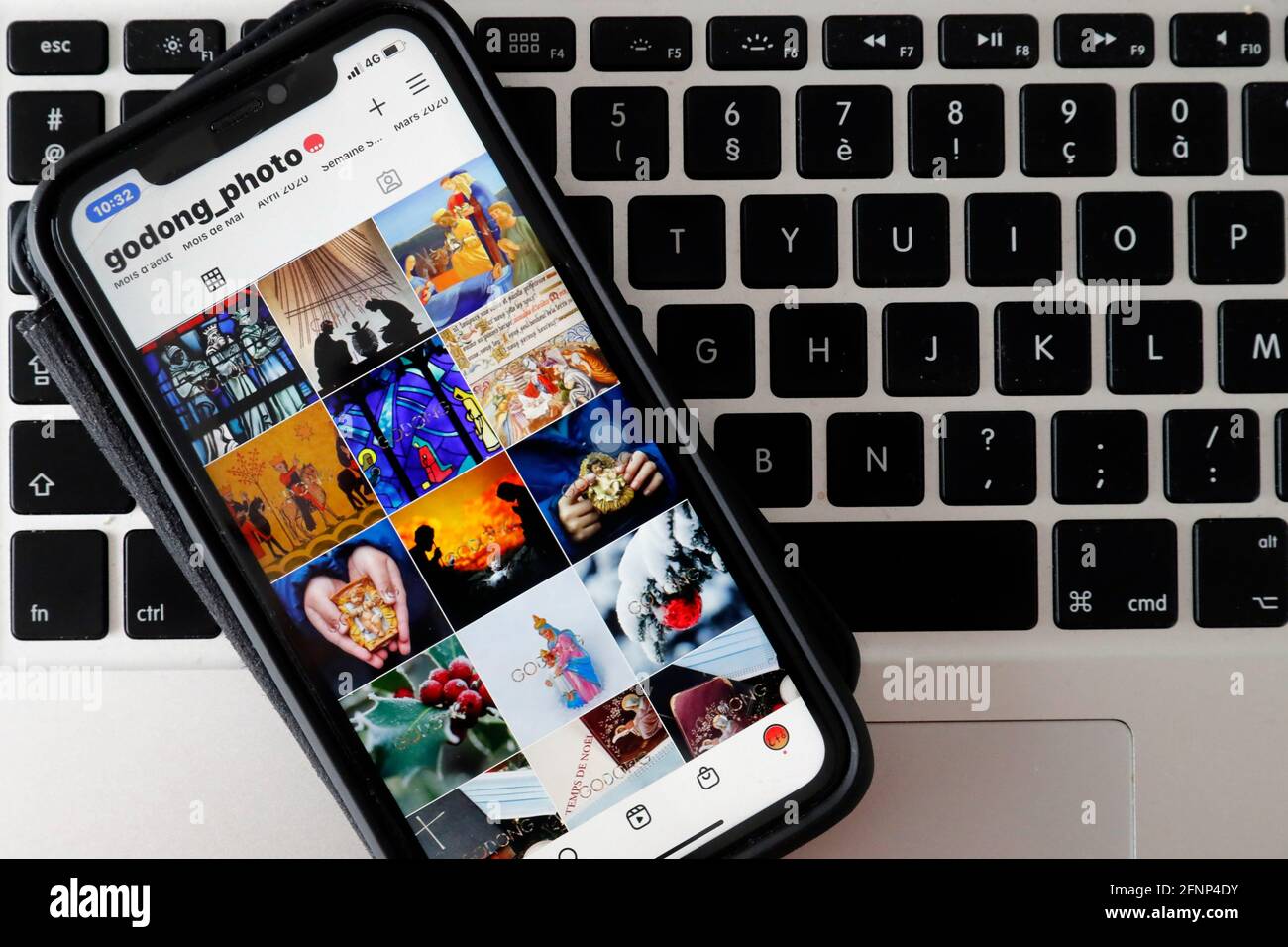 IPhone auf einer Laptop-Tastatur mit der Explore-Seite der Instagram-App mit katholischen Bildern. Frankreich. Stockfoto