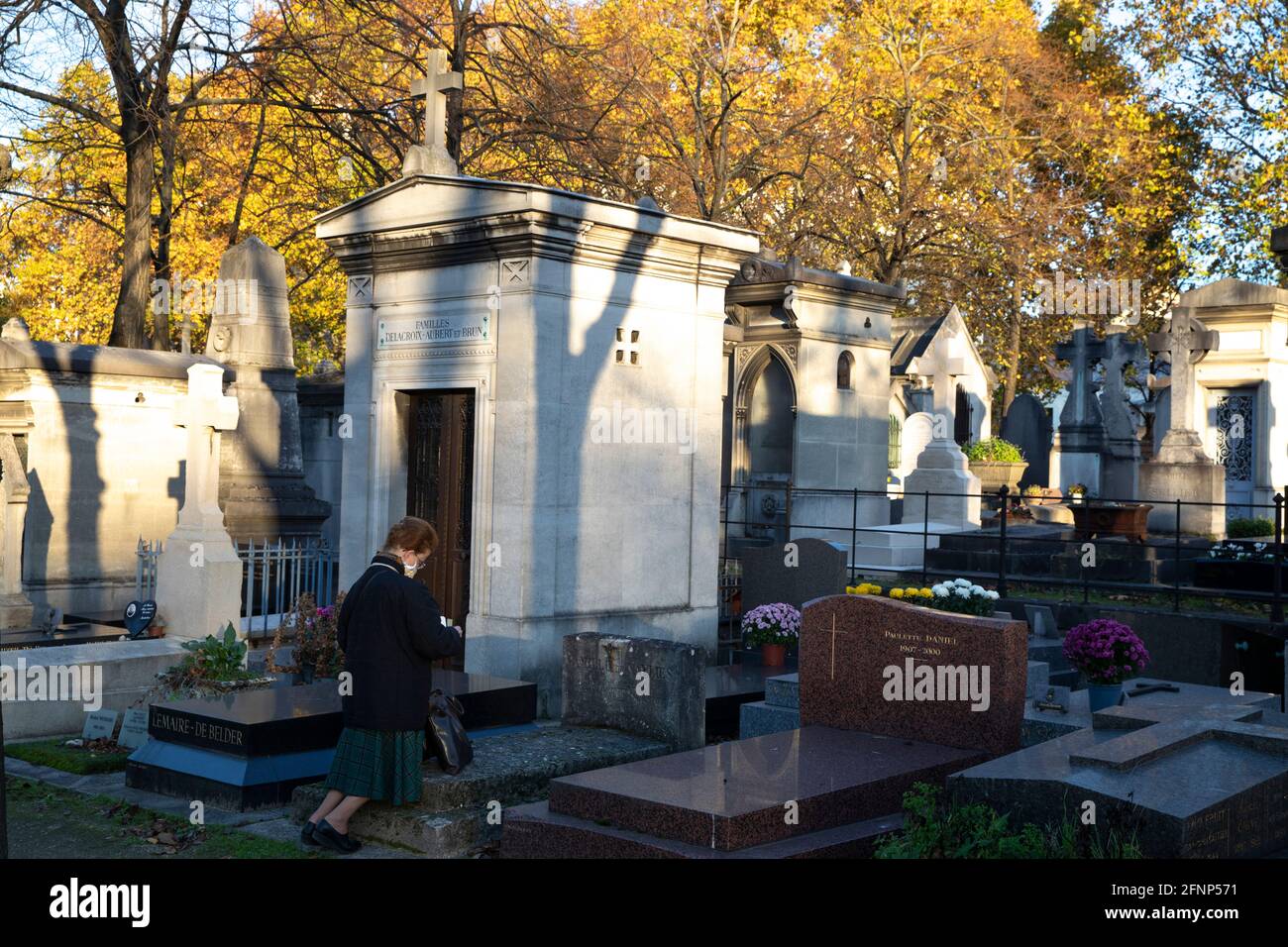 Frau, die auf dem Friedhof von Montparnasse kniet und betet (französisch: cimetiere du Montparnasse), Paris, Frankreich Stockfoto