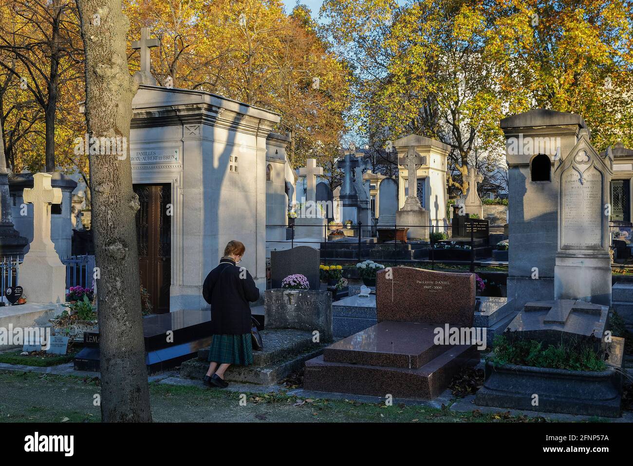 Frau, die auf dem Friedhof von Montparnasse kniet und betet (französisch: cimetiere du Montparnasse), Paris, Frankreich Stockfoto