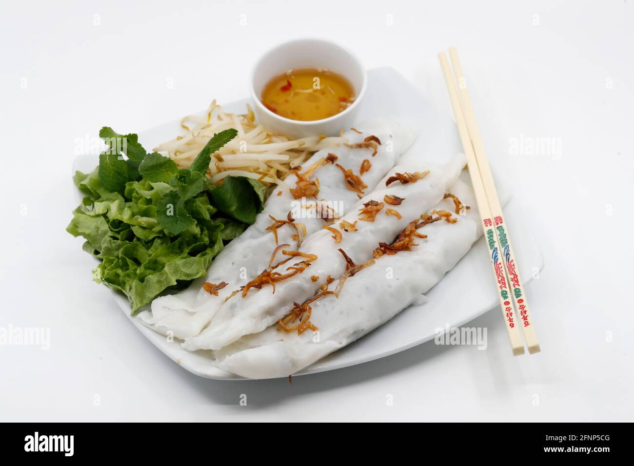 Vietnamesisches Essen. Banh Cuon wird aus einem dünnen, breiten Blatt gedünsteter fermentierter Reisteig hergestellt, der mit einer Mischung aus gekochtem, gewürztem, gemahlenem Schweinefleisch, min., gefüllt ist Stockfoto