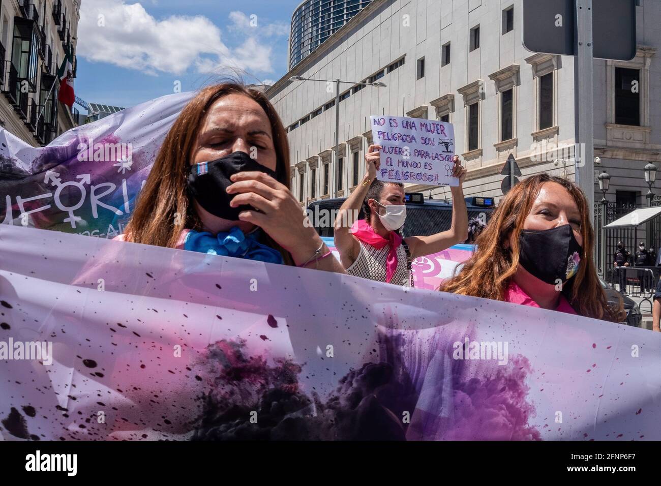 Demonstranten, die Gesichtsmasken tragen, halten während des Protestes Flaggen fest und singen Slogans. Aktivisten der Trans Community protestieren vor dem Abgeordnetenkongress. Die Abstimmung über die Bearbeitung des "transstaatlichen Gesetzes" wird am Dienstag, dem 18. Mai, in der Plenarsitzung des spanischen Kongresses diskutiert. Stockfoto