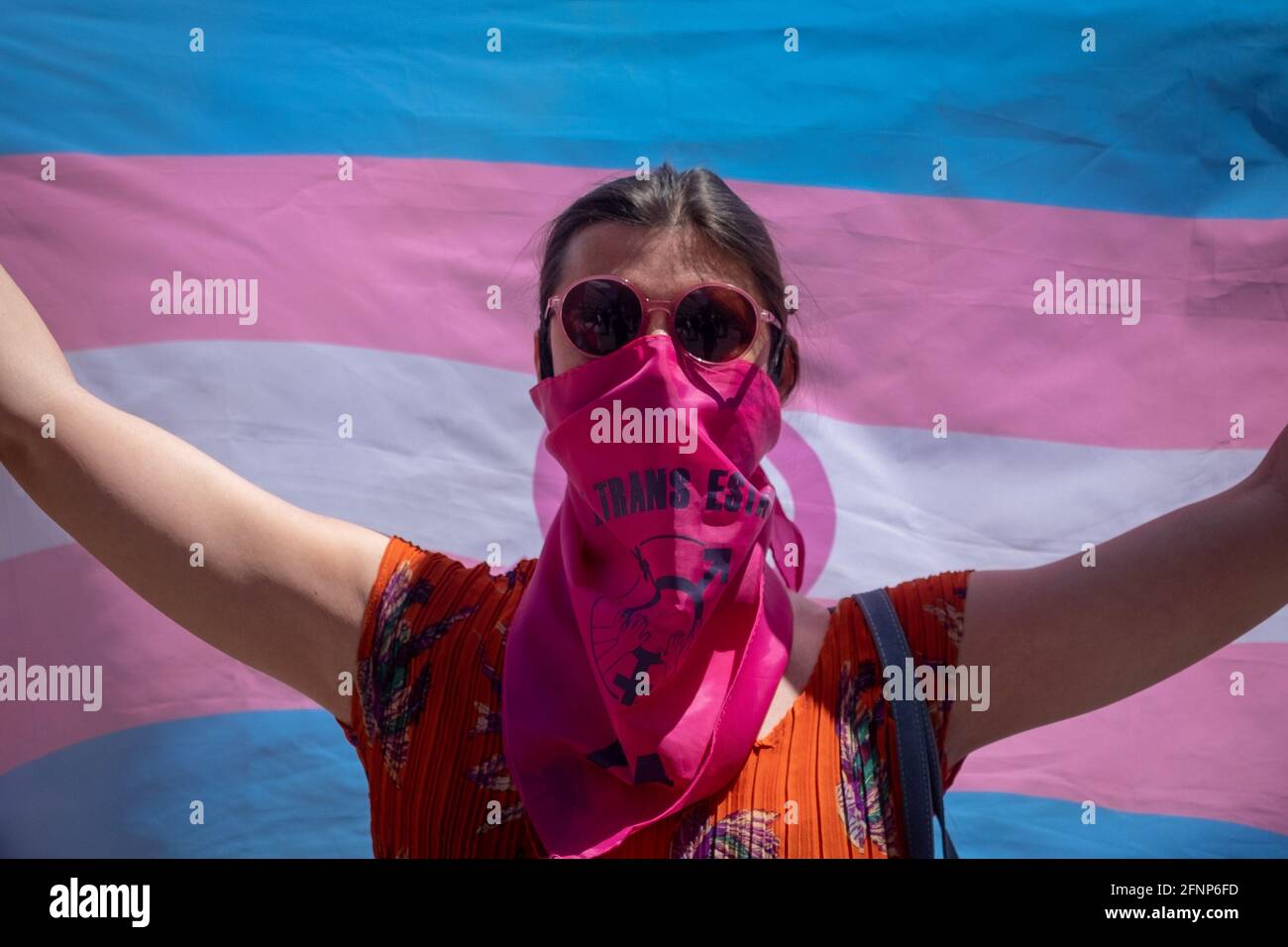 Während des Protestes wird ein Aktivist mit einer Gesichtsmask gesehen, der die Trans-Flaggen hält. Aktivisten der Trans Community protestieren vor dem Abgeordnetenkongress. Die Abstimmung über die Bearbeitung des "transstaatlichen Gesetzes" wird am Dienstag, dem 18. Mai, in der Plenarsitzung des spanischen Kongresses diskutiert. Stockfoto