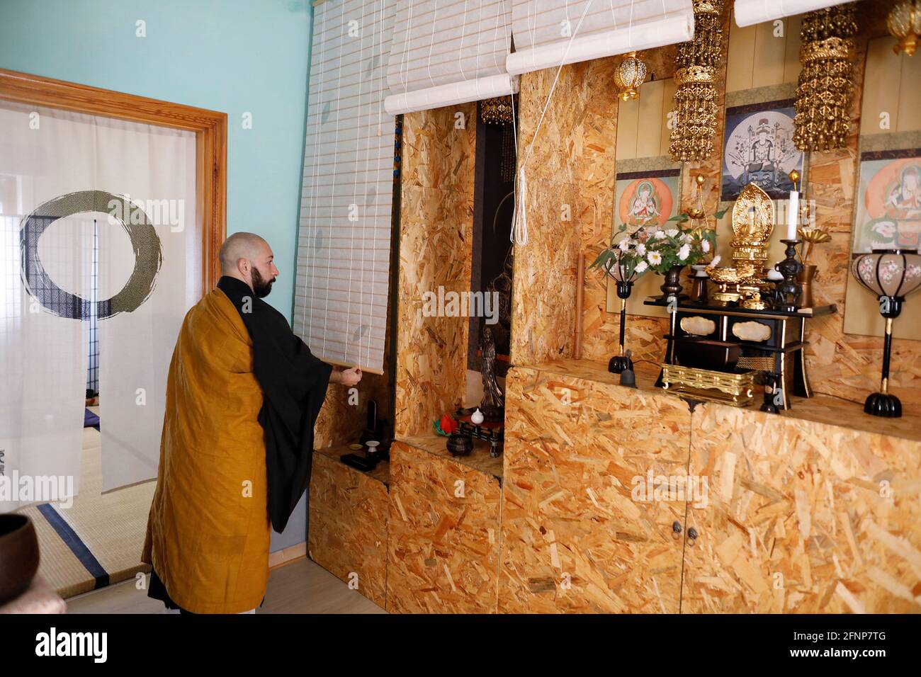 Zen Dojo in Marrubiu, Sardinien, Italien. Meister hebt die Altarvorhänge an Stockfoto