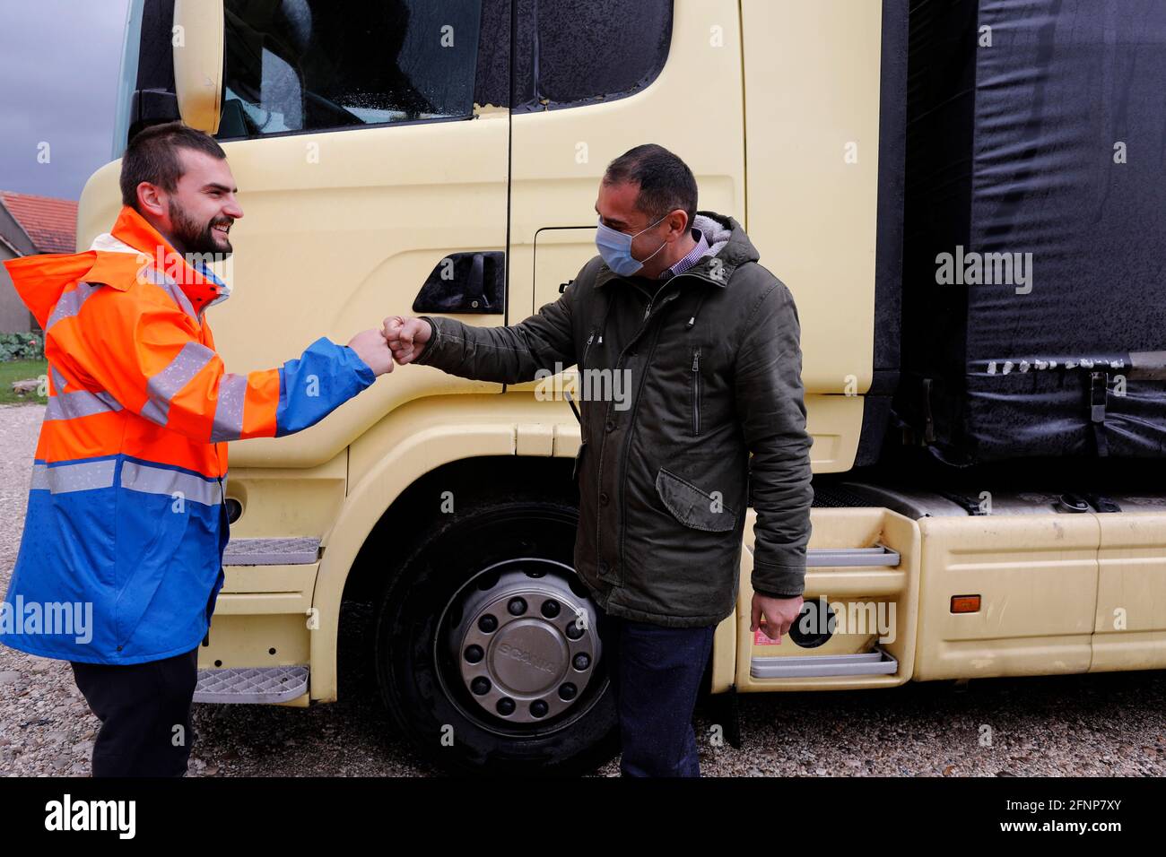 LKW-Fahrer begrüßt einen Mitarbeiter für Mikrofinanzkredite während der Pandemie von Covid-19 in Nikcic, Montenegro Stockfoto