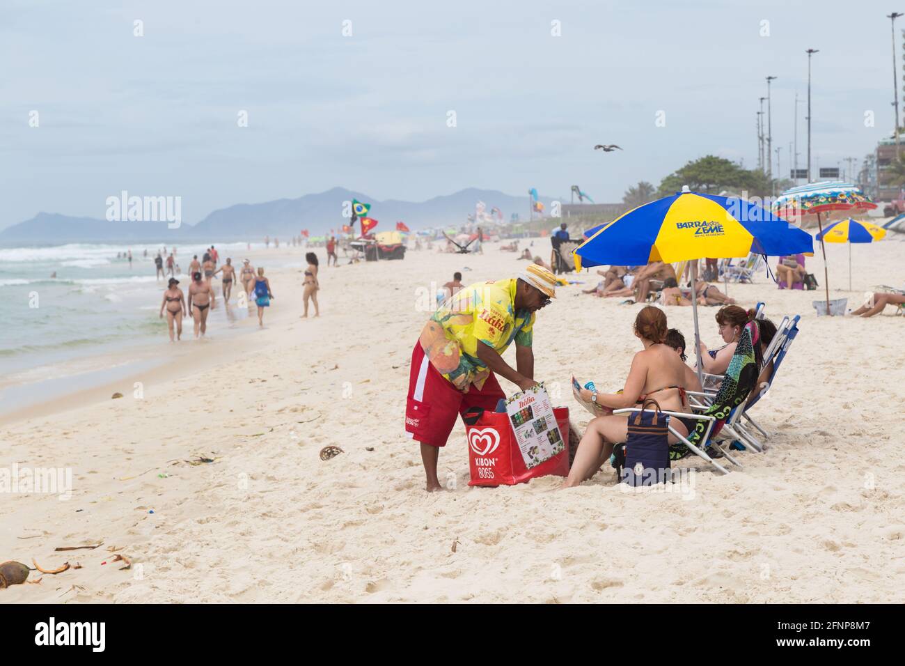 BARRA da TIJUCA, RIO DE JANEIRO, BRASILIEN - 2. JANUAR 2020: Eisverkäufer am Strand, der seine Produkte den Menschen anbietet. Stockfoto
