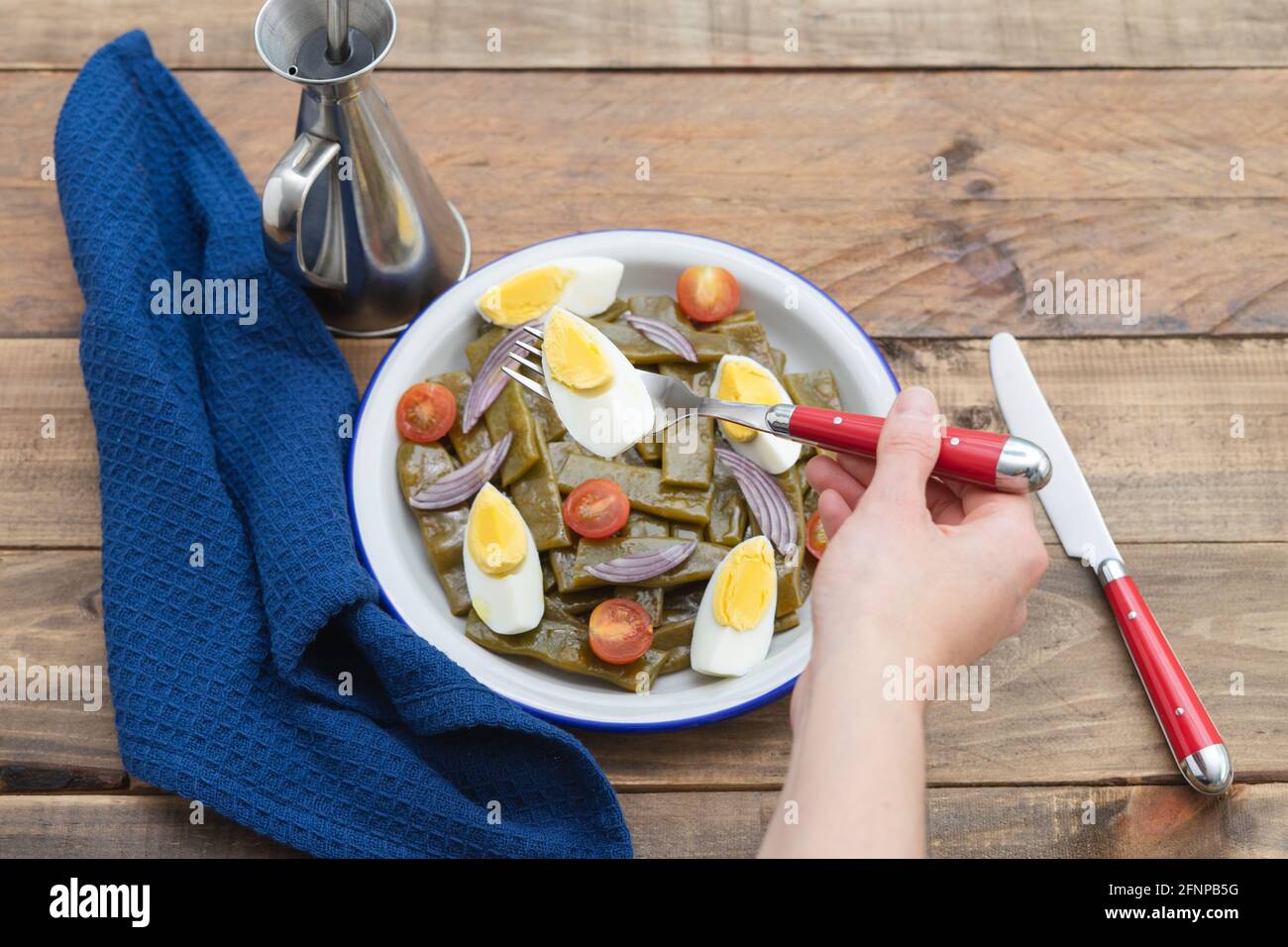 Grüner Bohnensalat mit gekochtem Ei und Tomaten. Salat mit der Hand der ... Grüner Bohnensalat mit gekochtem Ei und Tomaten. Salat mit der Hand der ...