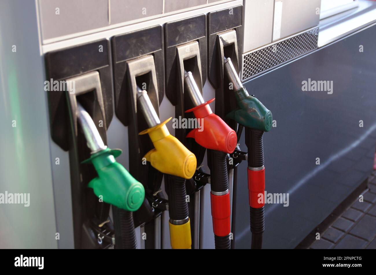 Zapfsäule an einer Tankstelle. Schläuche mit Dosierpistolen für verschiedene Kraftstoffarten. Stockfoto