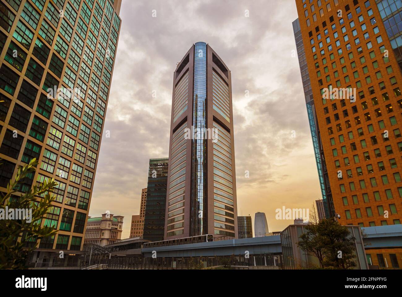 Moderne Architektur in Tokio. Shimbashi District Moderne Wolkenkratzer bei Sonnenuntergang mit Yurikamome Metro-Linie Stockfoto