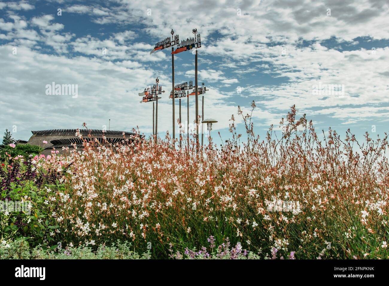 Nida, eine Kurstadt in Litauen an der Kurischen Nehrung. Traditionelle bunte Holz geschnitzte Wetterhähne mit blühenden Blumen.Wetter Schaufeln zeigen Stockfoto