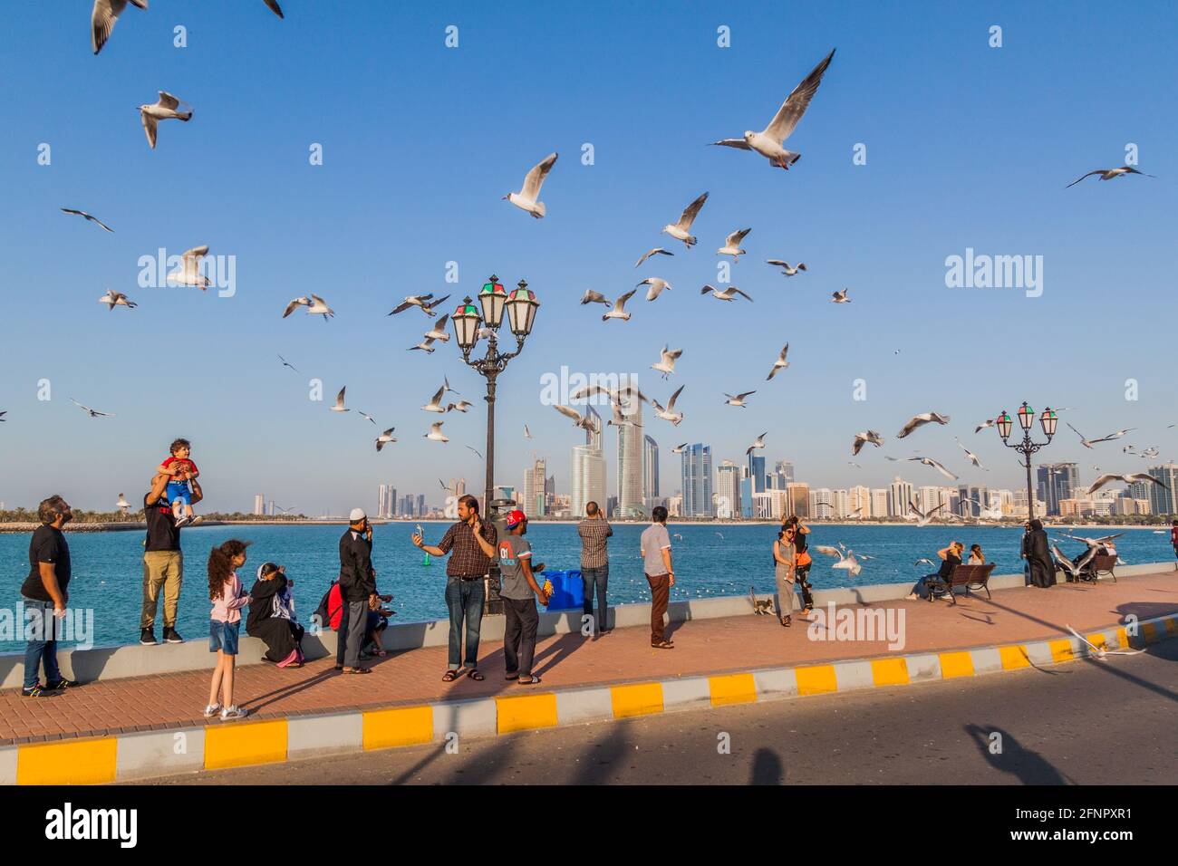 ABU DHABI, VAE - 7. MÄRZ 2017: Die Menschen beobachten die Skyline von Abu Dhabi von der Marina Breakwater aus, Vereinigte Arabische Emirate Stockfoto