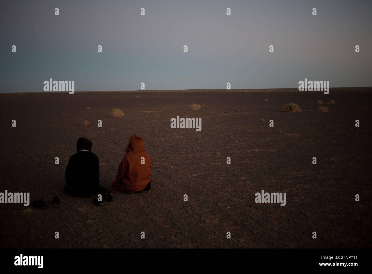 Befreite Gebiete, Westsahara. Zwei sahrauische Männer, die das letzte Gebet des Tages in der Wüste verrichten. Die Sahrawi üben eine moderate und tolerante FO Stockfoto