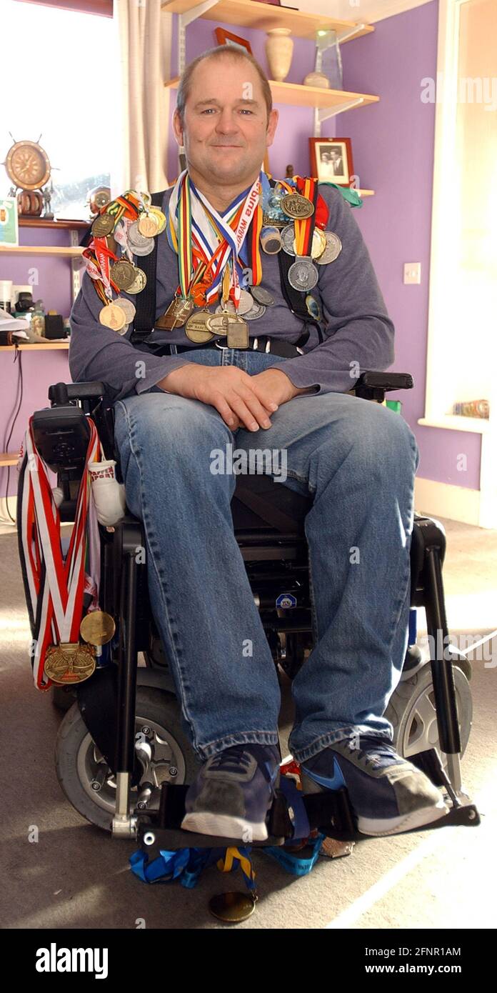 DER EHEMALIGE ROYAL NAVY DIER MIKE MARTEN AUS FAREHAM , HANTS MIT EINIGEN SEINER PARAPLEGIC-MARATHON-MEDAILLEN PIC MIKE WALKER, 2004 Stockfoto