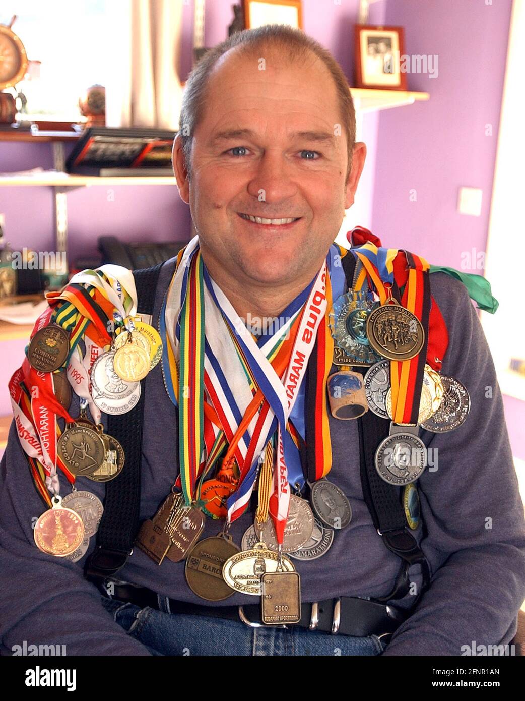 DER EHEMALIGE ROYAL NAVY DIER MIKE MARTEN AUS FAREHAM , HANTS MIT EINIGEN SEINER PARAPLEGIC-MARATHON-MEDAILLEN PIC MIKE WALKER, 2004 Stockfoto