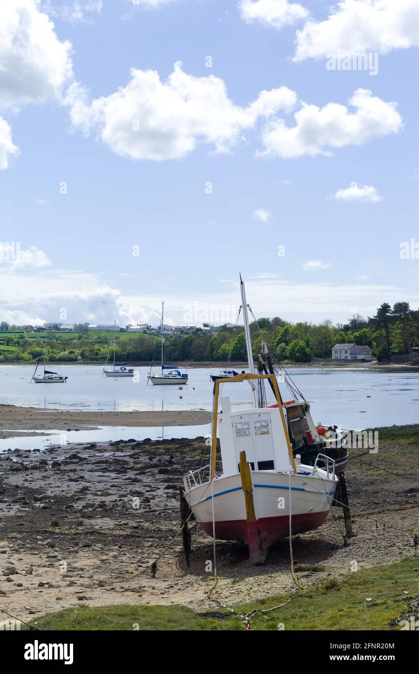 Anglesey, Red Wharf Bay. Traditionelles Fischerboot, das bei Ebbe auf Sandflächen festgemacht wird. Wunderschöne Meereslandschaft an einem Frühlingstag. Vertikale Aufnahme – Platz zum Kopieren. Stockfoto
