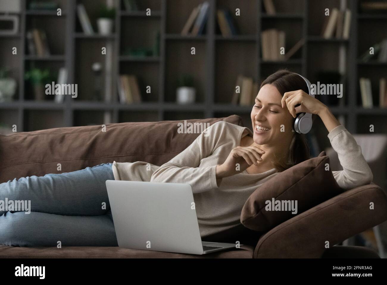 Teen weiblich in Kopfhörer mit Laptop, um Englisch online zu lernen Stockfoto