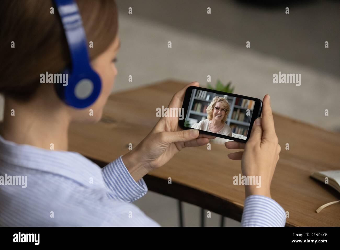Teen weiblich im Headset hören ältere Frau per Videocall Stockfoto
