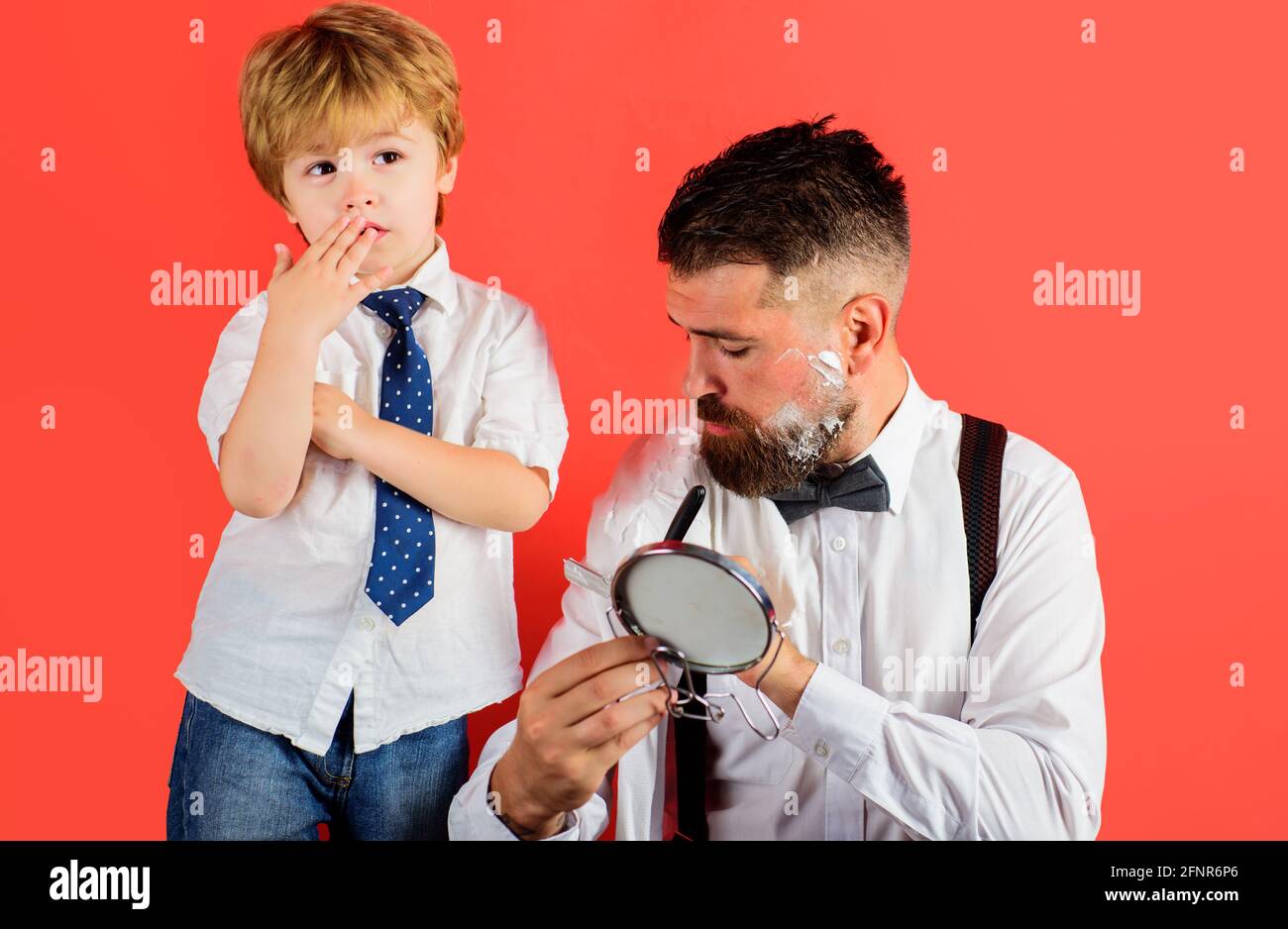 Vatertag. Sohn und Vater rasieren Bart. Zeit mit der Familie. Assistent für Papa. Kleiner Barbier. Barbershop. Stockfoto