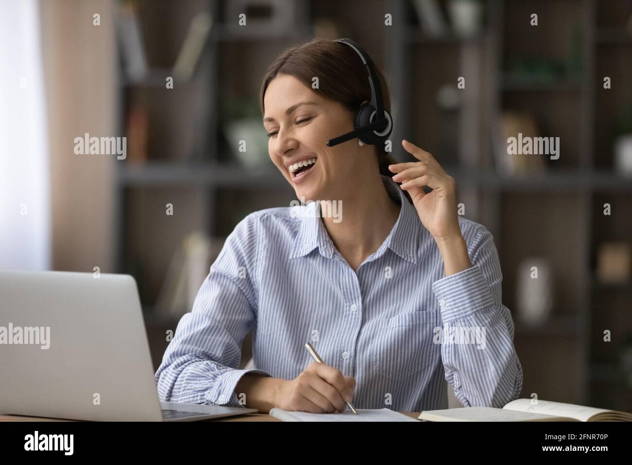 Fröhliche weibliche Studentin Handschrift Online-Lektion Lachen auf Lehrer Witz Stockfoto