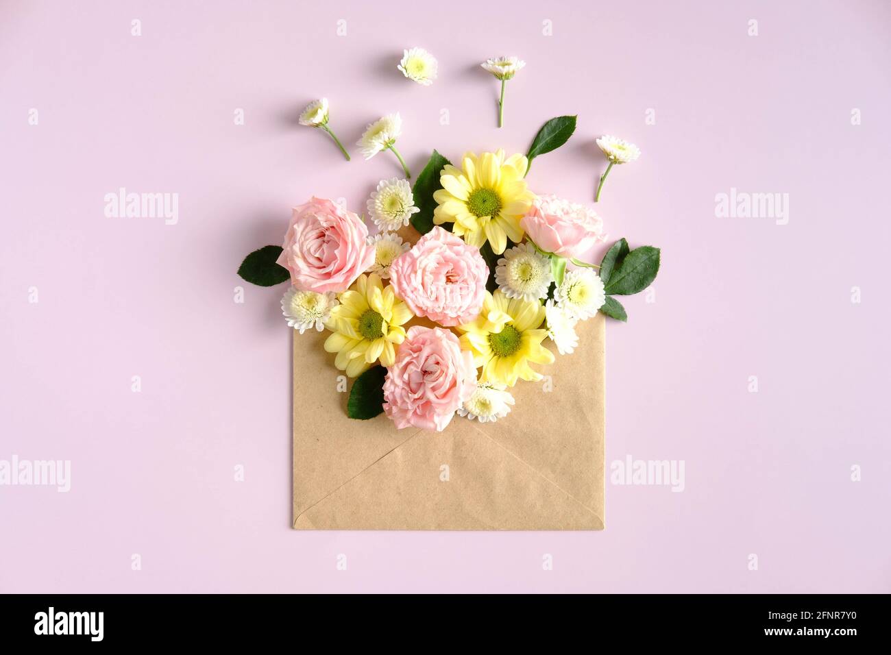 Briefumschlag mit Blumen auf rosa Hintergrund öffnen. Romantisch, Liebesbrief, Blumen Lieferkonzept. Stockfoto