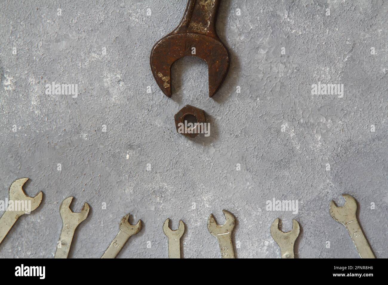 Schraubenmuttern und Schrauben auf Steinhintergrund. Vater und Söhne Konzept. Konzept zum Vatertag. Flach liegend. Stockfoto