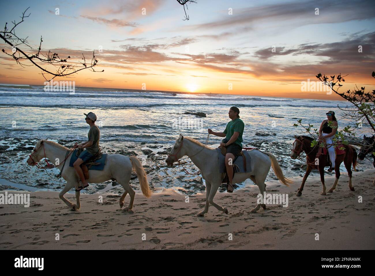 Reiter am Strand bei Sonnenuntergang in Costa Rica Stockfoto