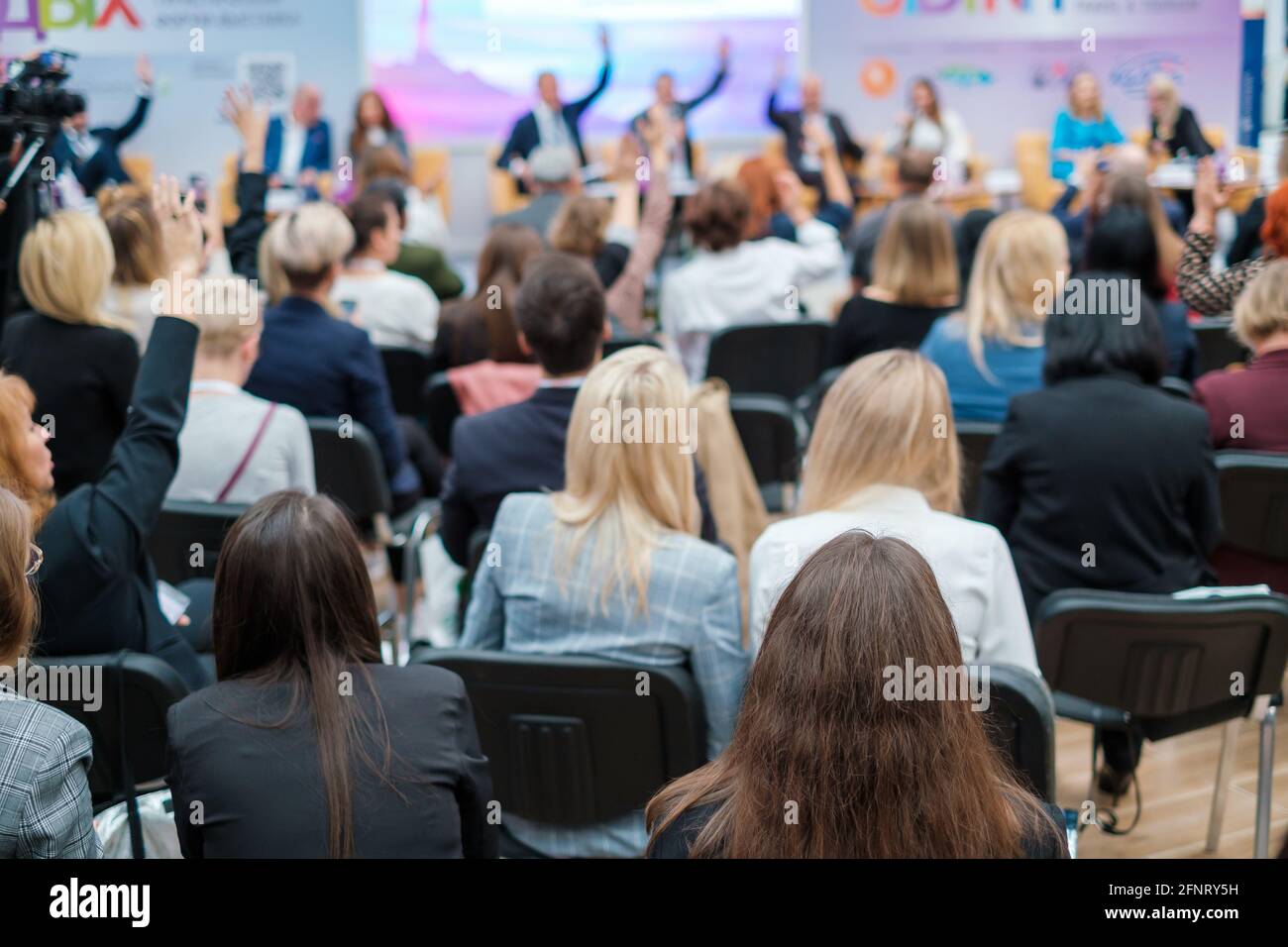 Gruppe von Geschäftsleuten, die während der Konferenz die Hände heben Stockfoto