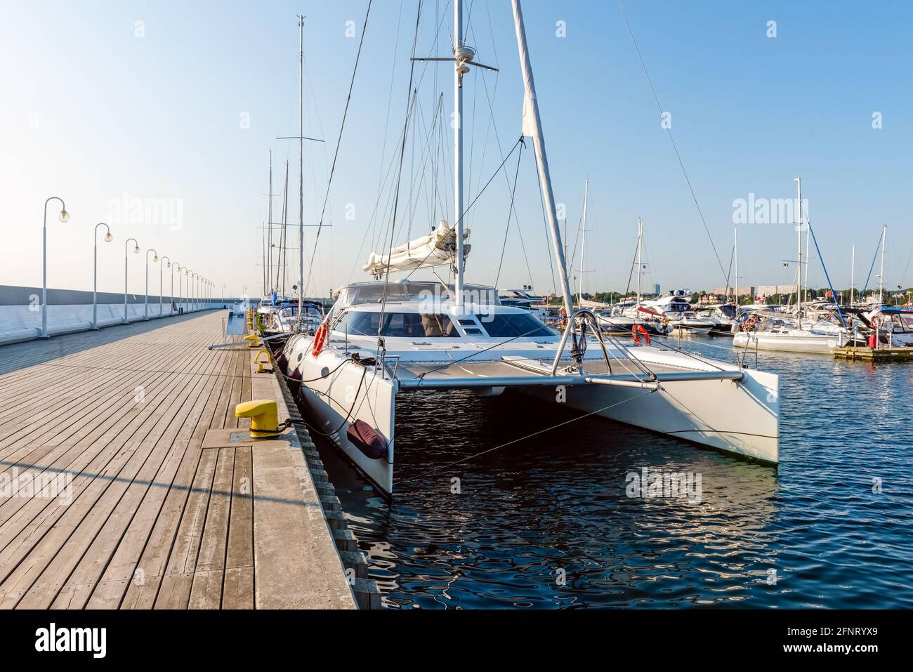 Segelyachten liegen an einem sonnigen Morgen an einem Pier in einem Hafen an der ostsee. Nautisches Schiff für Charter Stockfoto