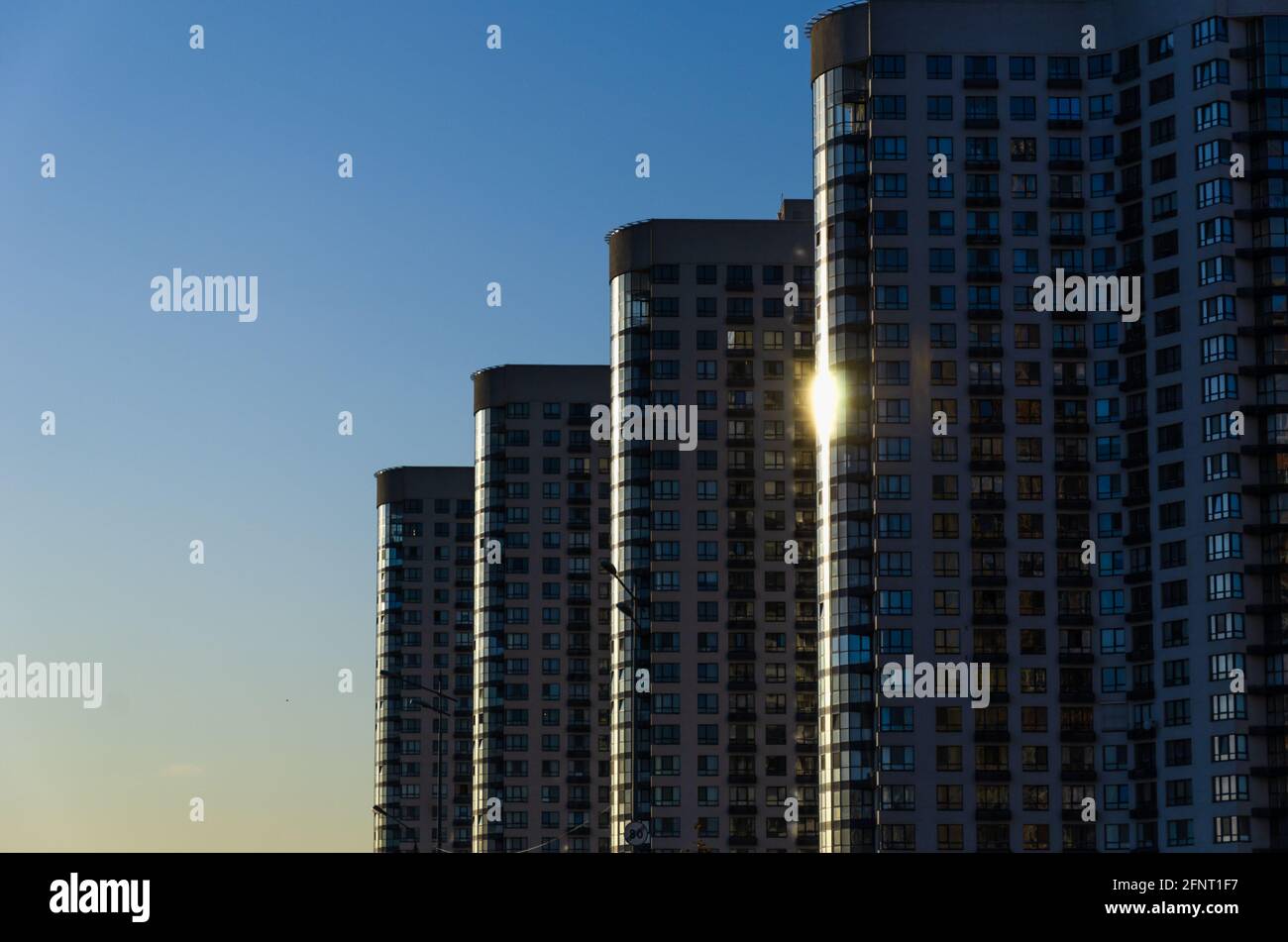 Eine Reihe moderner Hochhäuser mit Blick auf den klaren blauen Himmel. Städtischer Hintergrund. Konzept der Zersiedelung. Im Freien Stockfoto