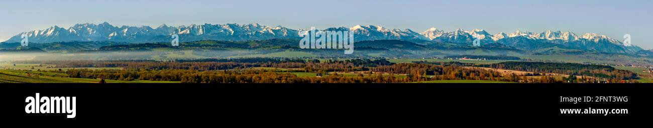 Extra breites Panorama der Tatra mit Wäldern Hügeln und Wiesen in der Region Podhale in Polen. Frühmorgens im Frühling, Morgennebel, Sonnenaufgang l Stockfoto