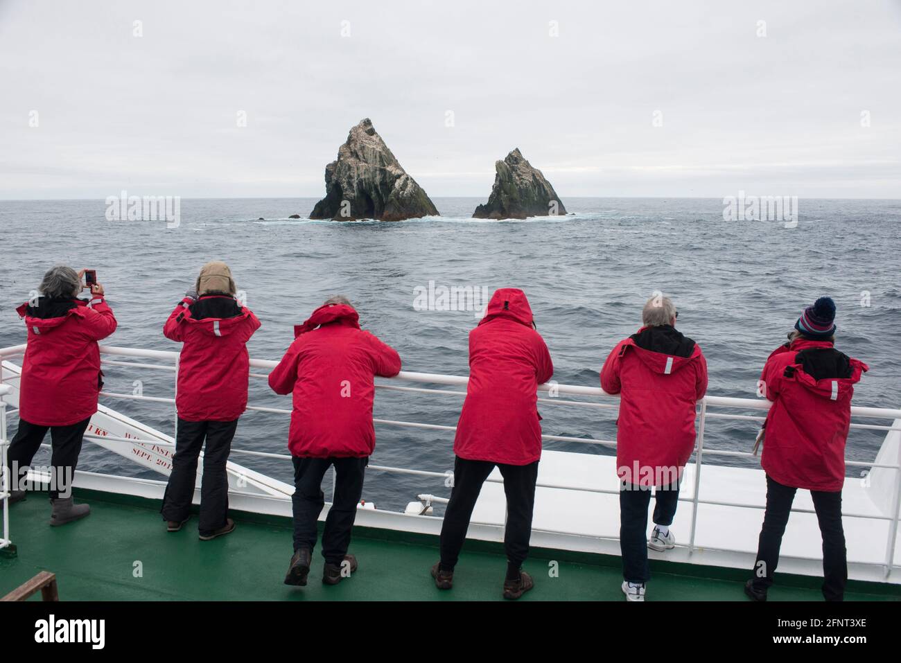 Touristen beobachten Vögel, wie ihr Schiff zwischen Shag Rocks vorbeifährt Südgeorgien und die Falklandinseln Antarktis Stockfoto