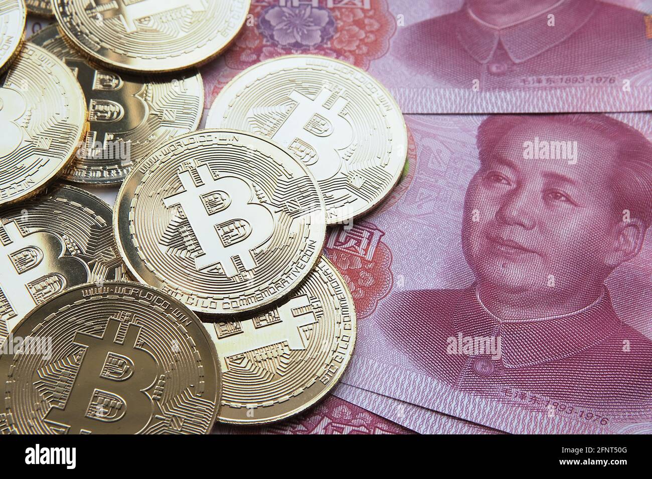 Bitcoin in China Konzept. Bitcoin-Münzen auf Yuan-Banknoten platziert. Verbot von Bitcoin in der Republik China. Stockfoto