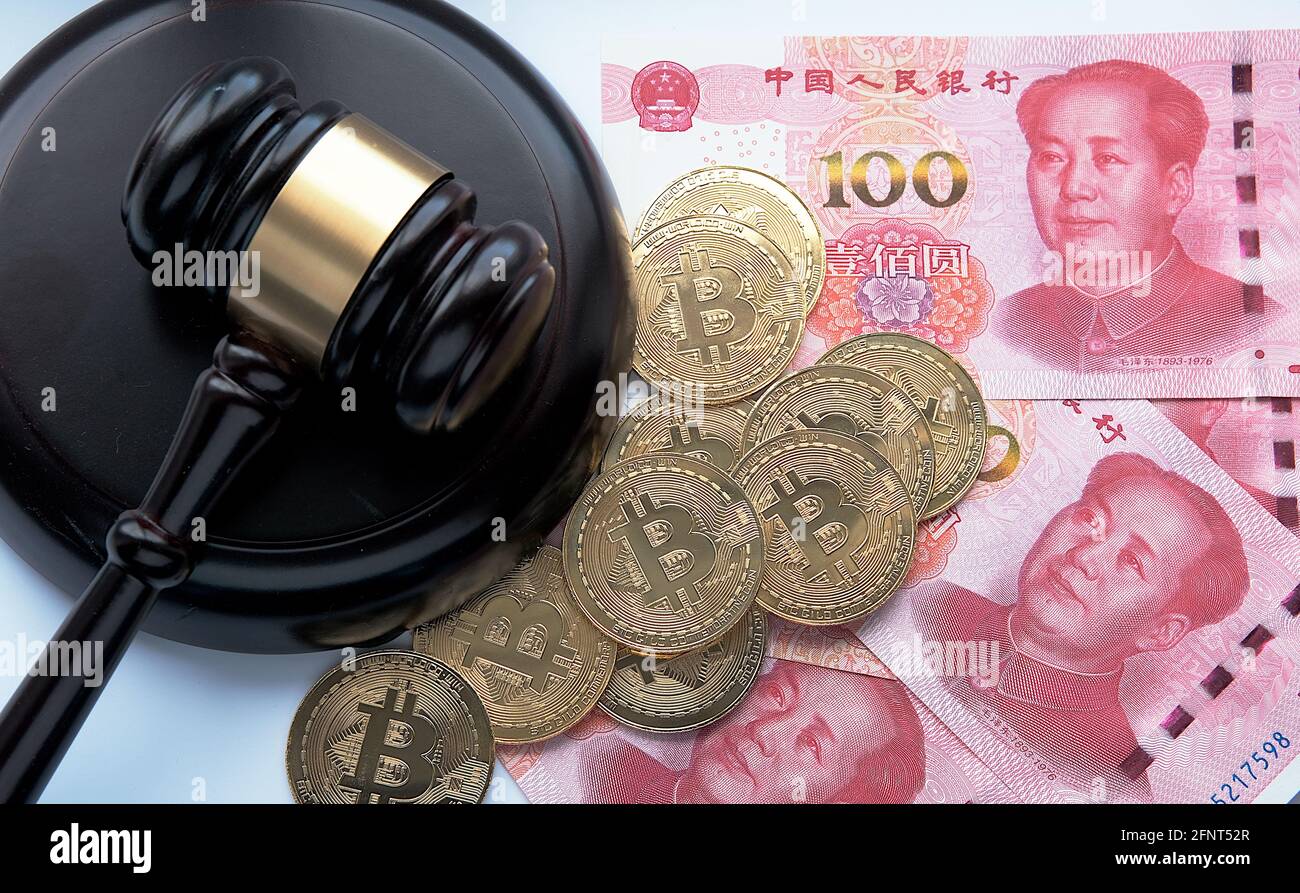 Bitcoin in China Konzept. Bitcoin-Münzen auf Yuan-Banknoten platziert. Verbot von Bitcoin in der Republik China. Stockfoto