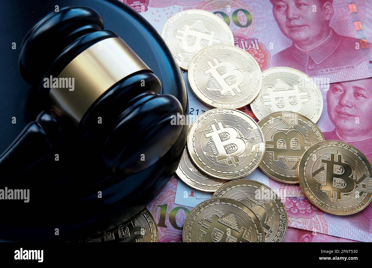 Bitcoin in China Konzept. Bitcoin-Münzen auf Yuan-Banknoten platziert. Verbot von Bitcoin in der Republik China. Stockfoto