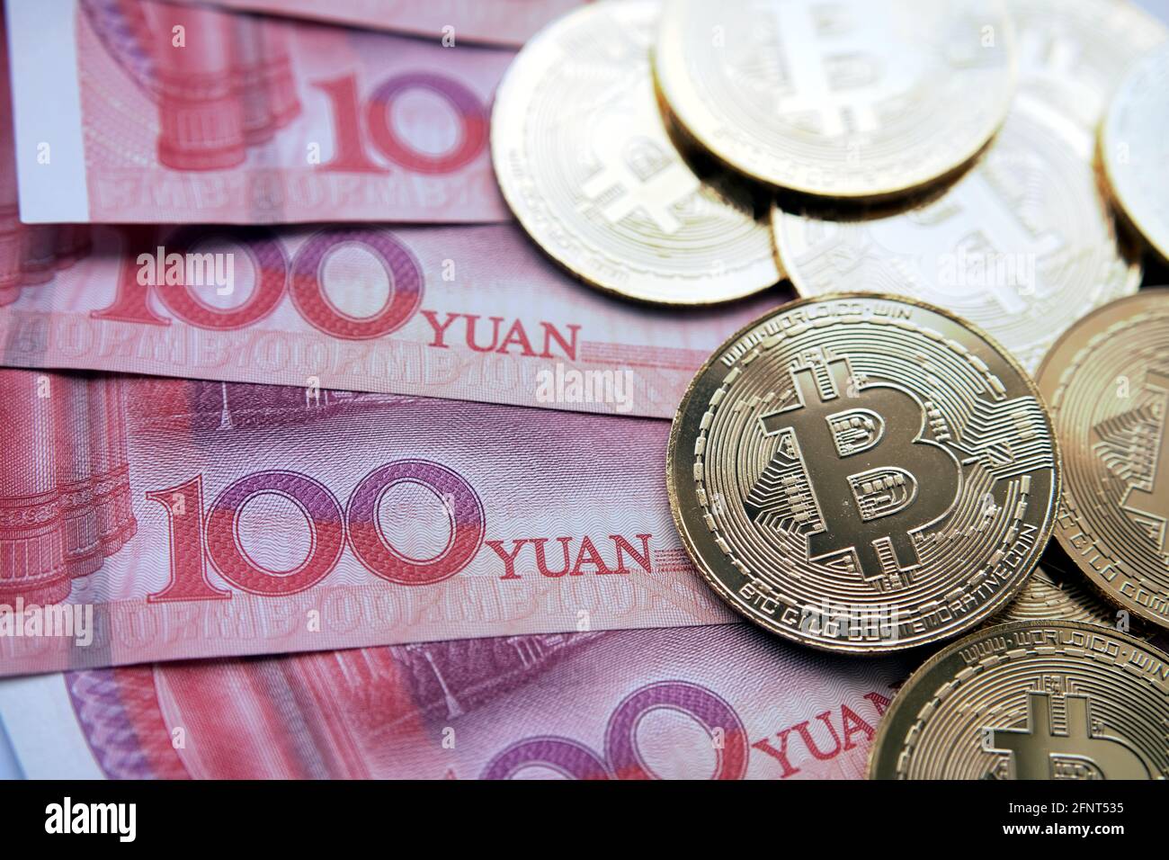 Bitcoin in China Konzept. Bitcoin-Münzen auf Yuan-Banknoten platziert. Verbot von Bitcoin in der Republik China. Stockfoto